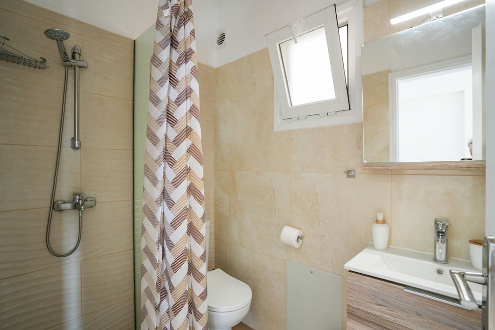 Modern studio bathroom with a walk-in shower and washbasin