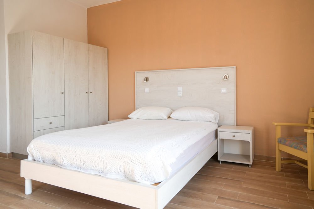 Bright bedroom with a double bed, wardrobe and terracotta accent wall
