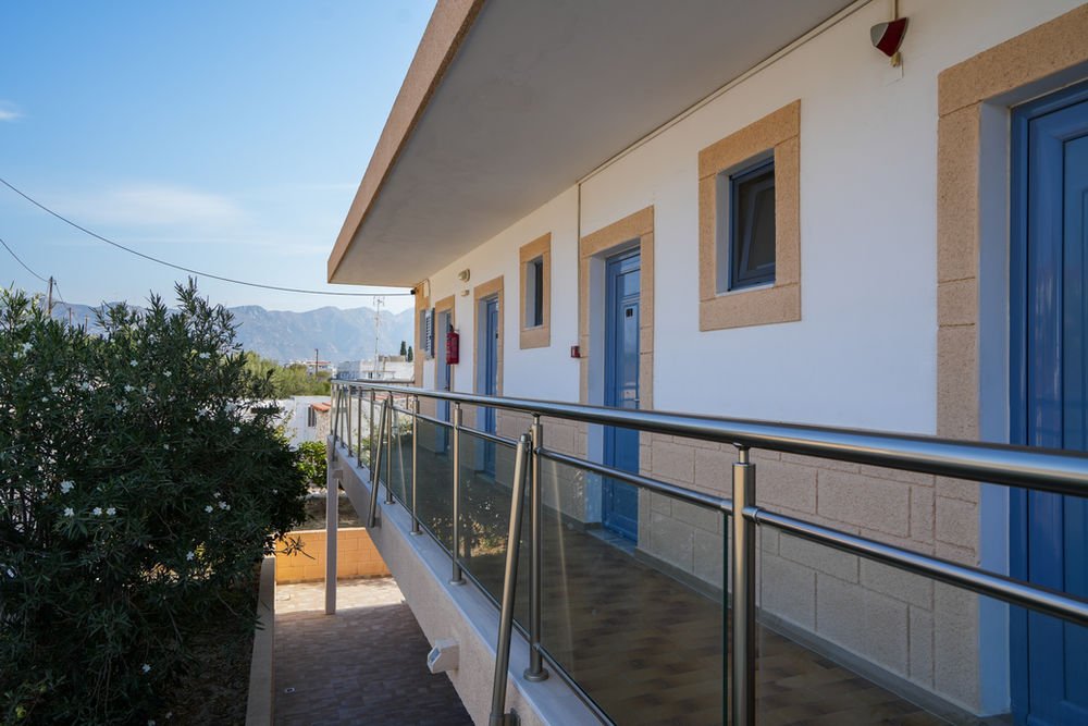 First-floor walkway with a glass balustrade and the blue doors of the studios