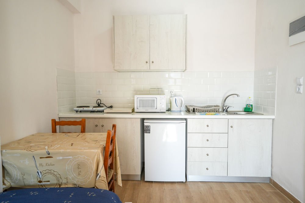 Studio kitchenette with fridge, microwave, cooking rings and a dining table