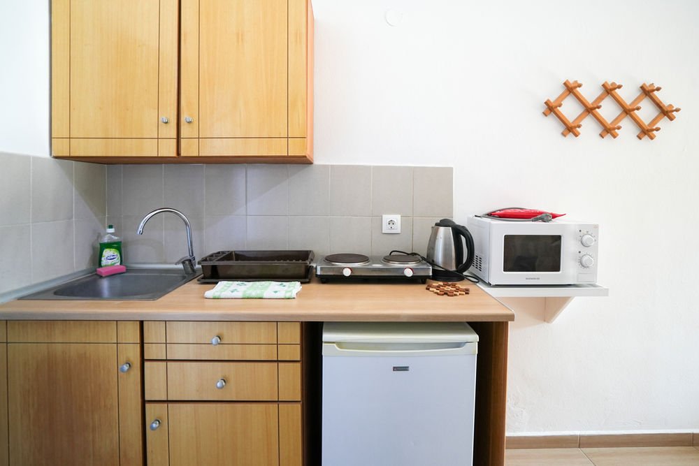 Kitchenette with a sink, cooking rings, kettle, microwave and fridge