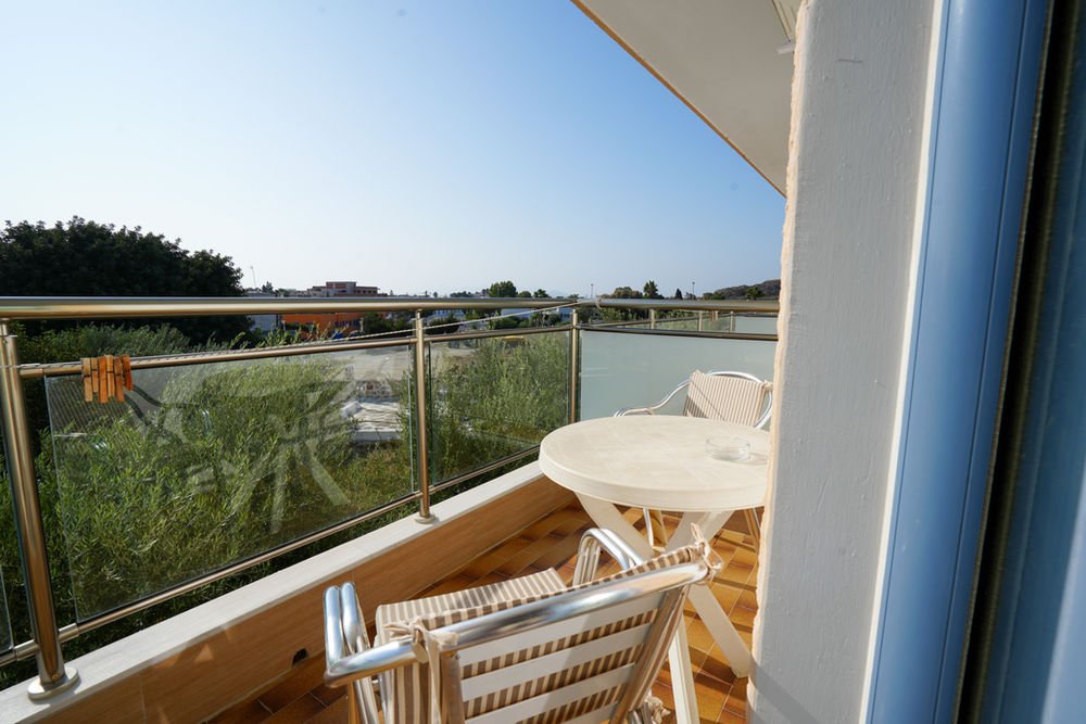 Furnished balcony with a table and chairs looking over the pool