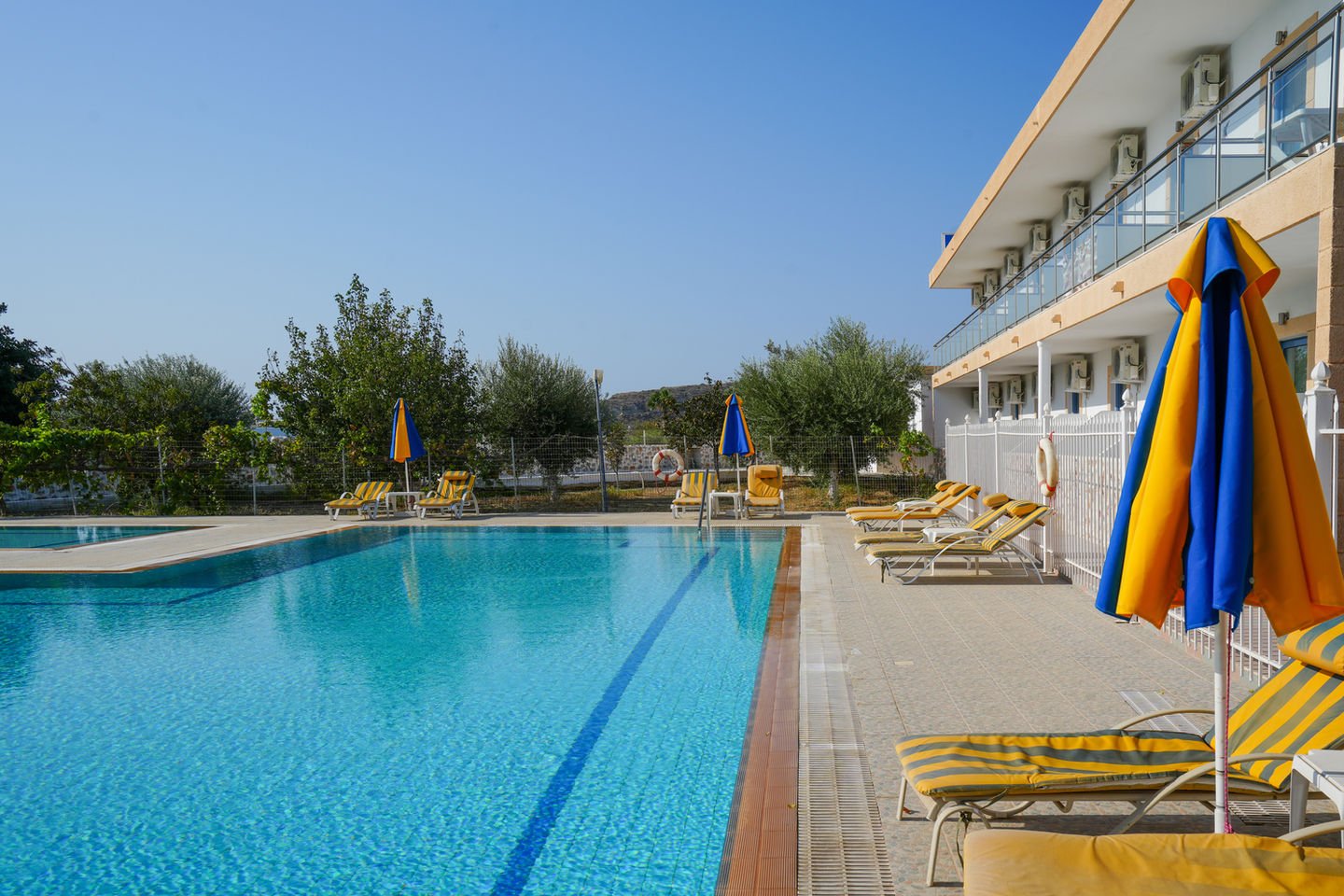 The outdoor swimming pool with sun loungers and parasols in front of Paraschos Studios, Kardamena